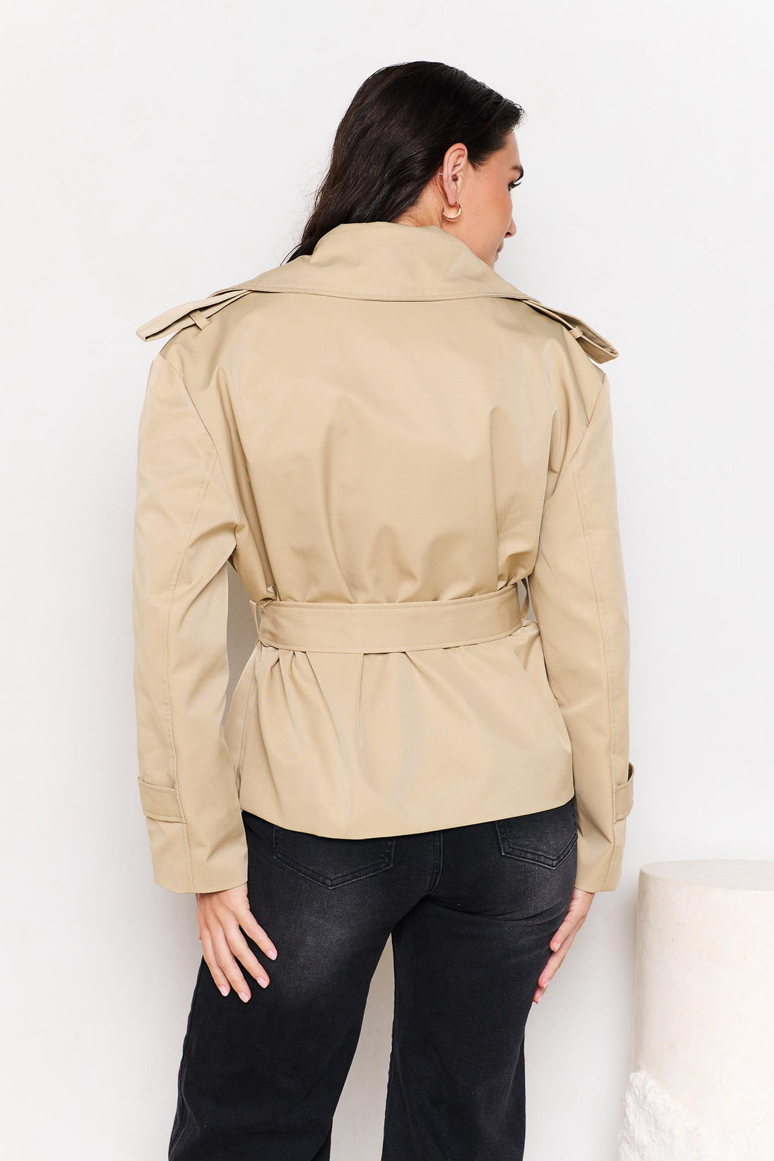 Back view of woman wearing a minnie + MAXXIE beige cropped trench coat