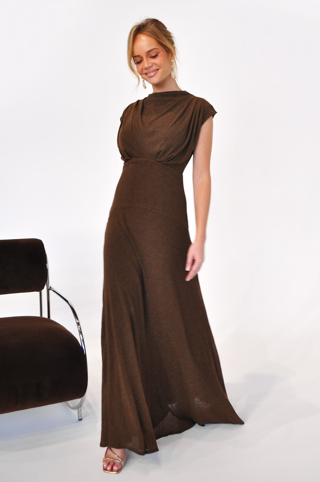 Woman wearing the cocoa brown Brigitte evening gown on a white background