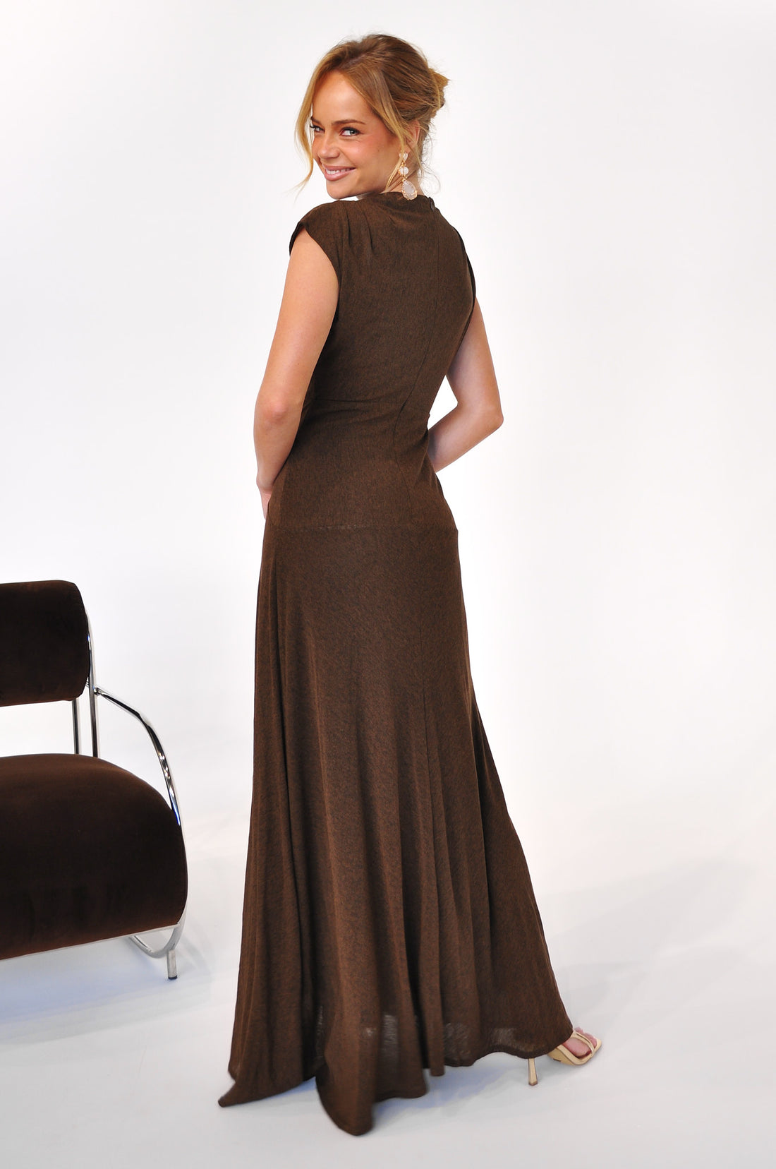 Back view of a woman wearing the Brigitte Gown, a cocoa brown maxi length event dress
