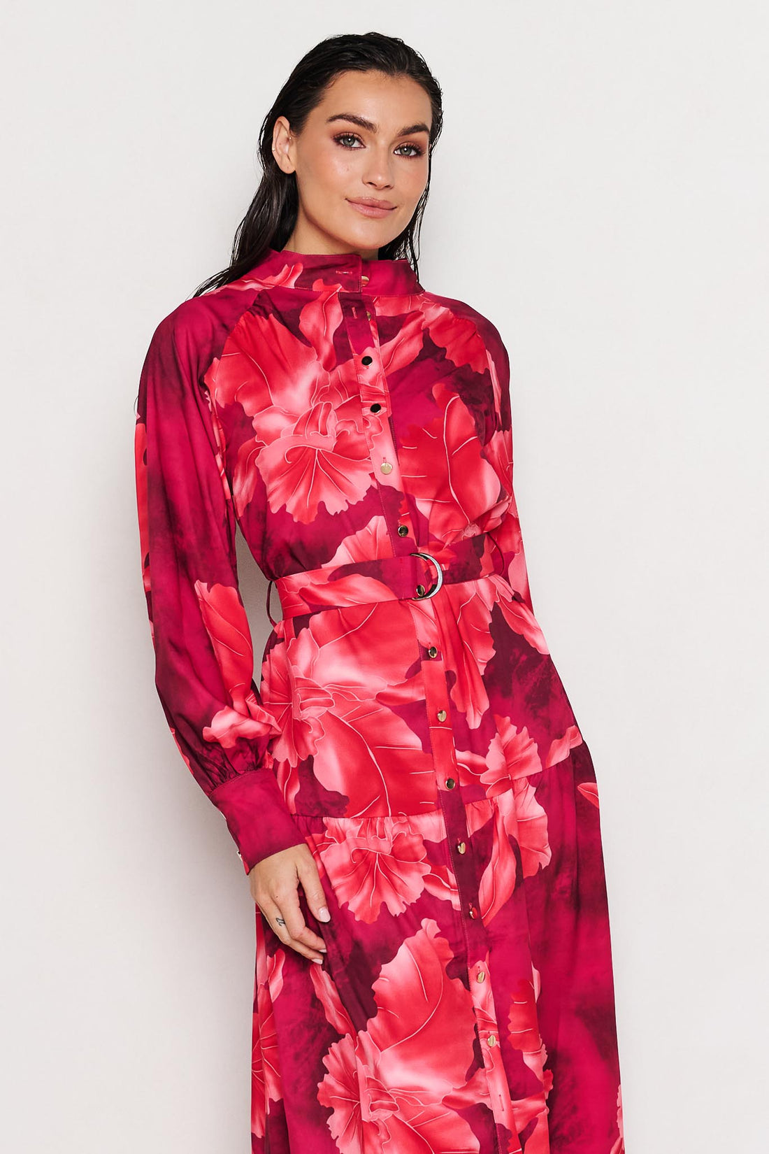 Woman wearing the minnie + MAXXIE Camille red floral midi dress on a white background