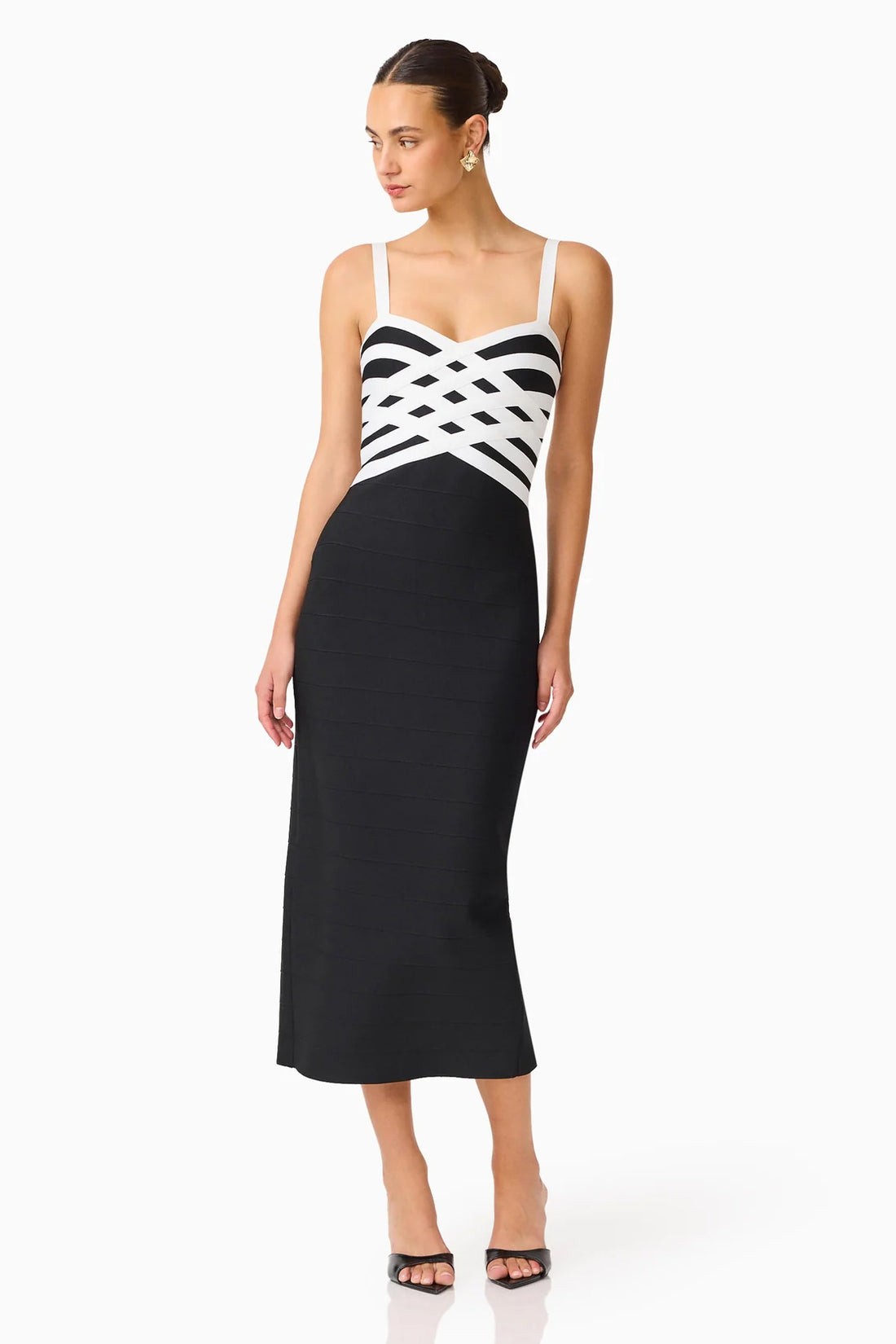 A model wearing the ELLIATT Ninette Column Midi Dress in Black & White with a white criss-cross strap pattern across the bodice, photographed against a plain white studio background.