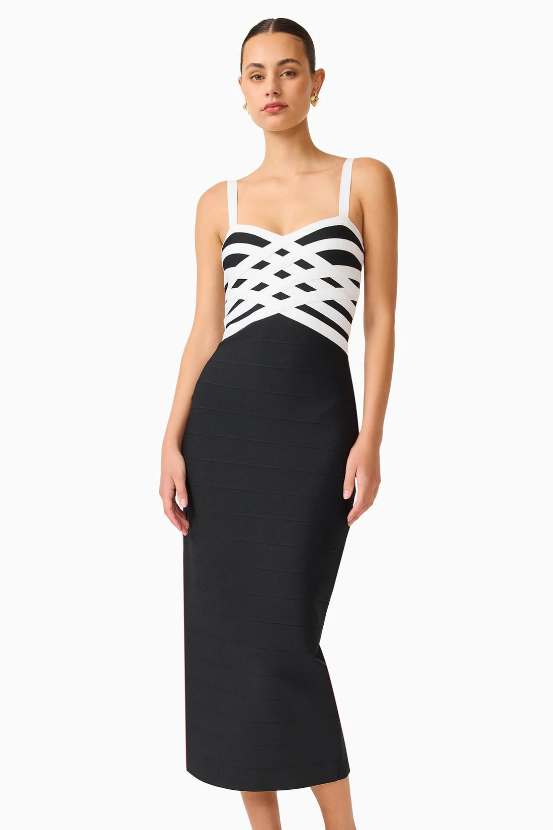 A model wearing the ELLIATT Ninette Column Midi Dress in Black & White with a white criss-cross strap pattern across the bodice, photographed against a plain white studio background.