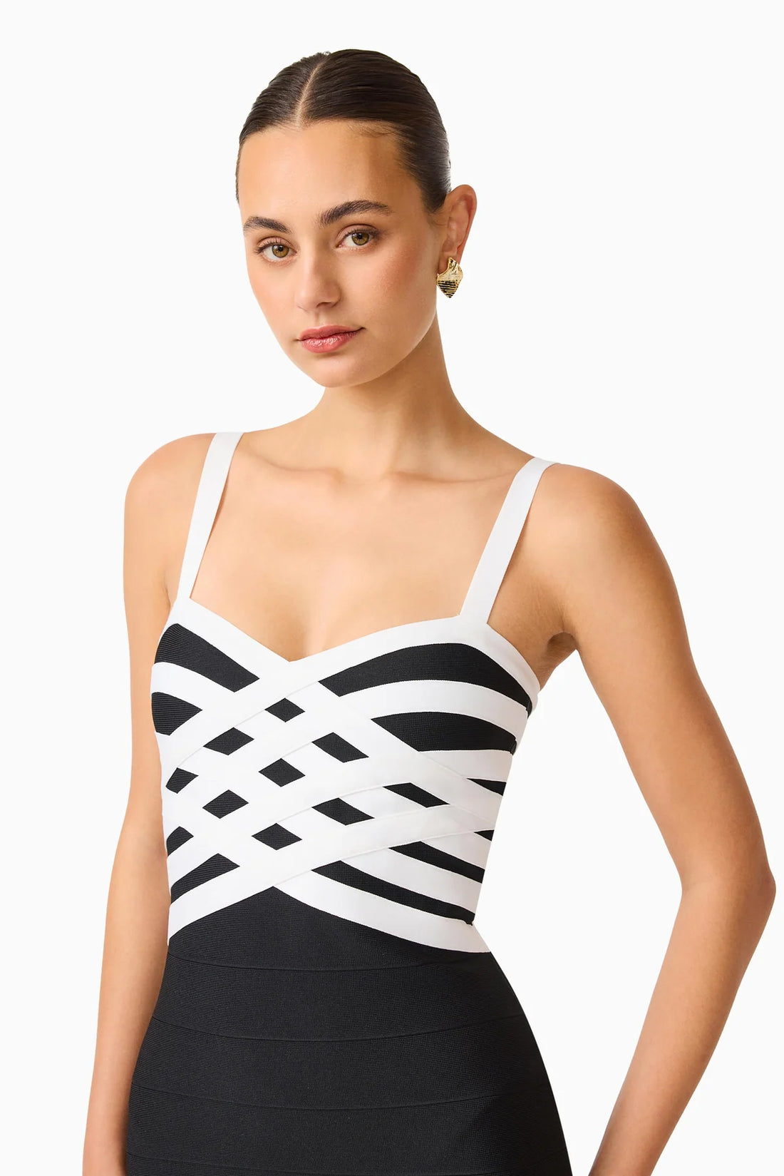 Detail of a model wearing the ELLIATT Ninette Column Midi Dress in Black & White with a white criss-cross strap pattern across the bodice, photographed against a plain white studio background.