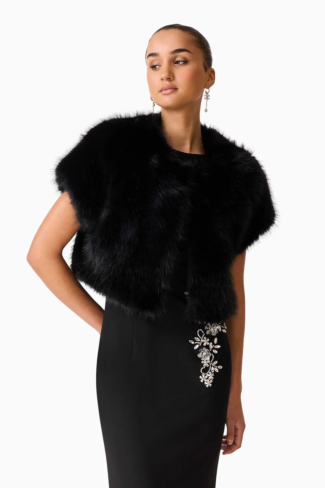 Close up of a woman wearing the ELLIATT Veda Gown with diamante embellishments and the Lucyna short sleeve bolero in black faux fur