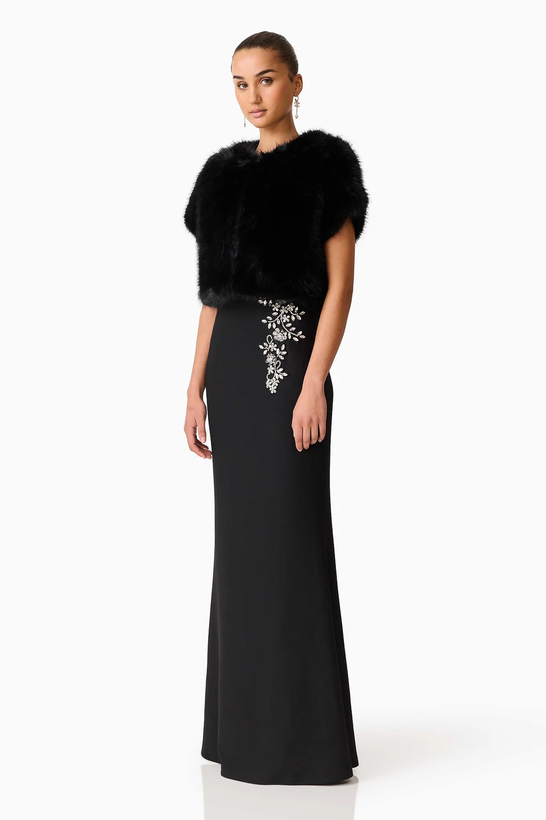 Woman wearing the ELLIATT black Veda gown with diamante embellishments and the Lucyna black faux fur bolero