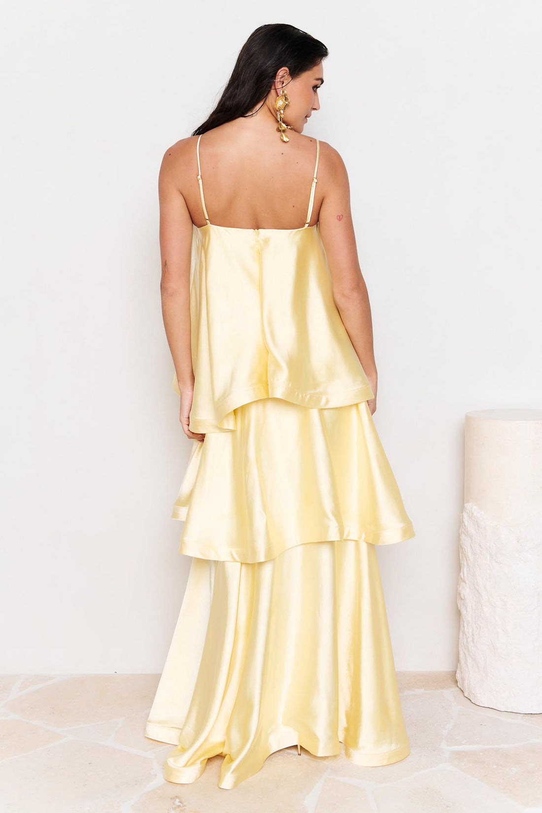 Back view of woman wearing the ELLIATT Tilly Tiered Maxi Dress in butter yellow evening gown on a white background