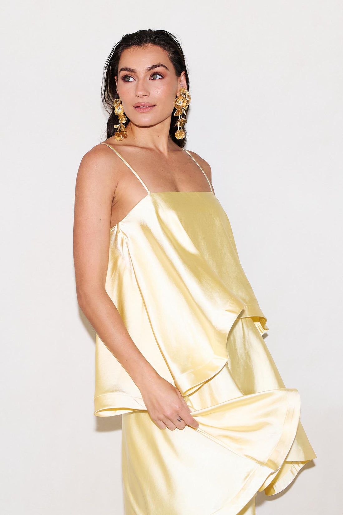 Close up of woman wearing the ELLIATT Tilly Tiered Maxi Dress in butter yellow evening gown on a white background