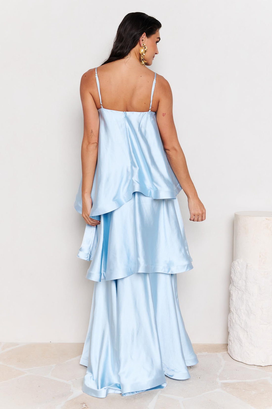 Back view of woman wearing the ELLIATT Tilly Tiered Maxi Dress in pale blue evening gown on a white background