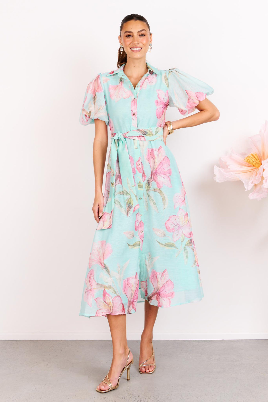 Woman wearing the minnie + MAXXIE La Belle aqua midi event dress with short puff sleeves and a matching waist tie.