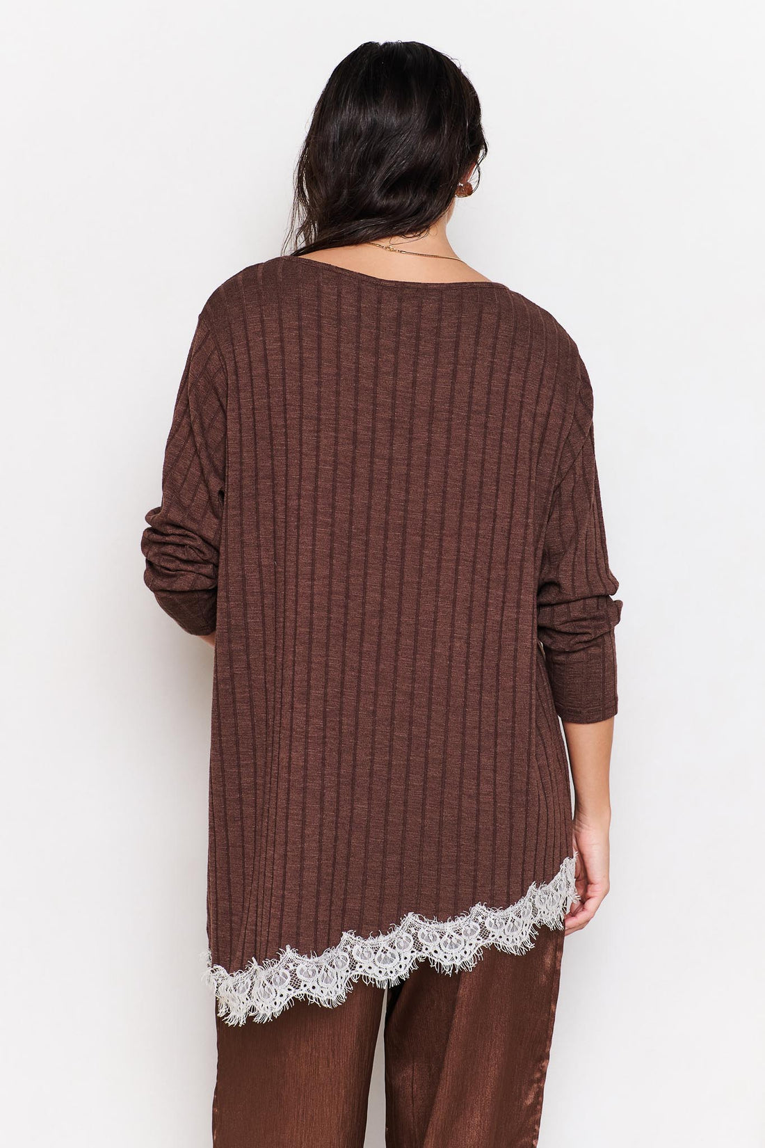 Woman wearing a brown ribbed sweater with lace trim on a white background