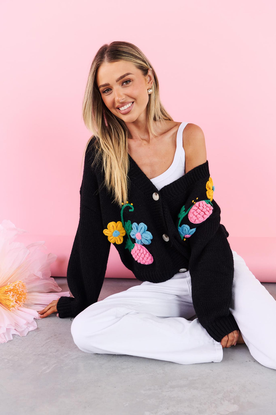 Lilah black Knit Cardigan with applique flowers against a pink background