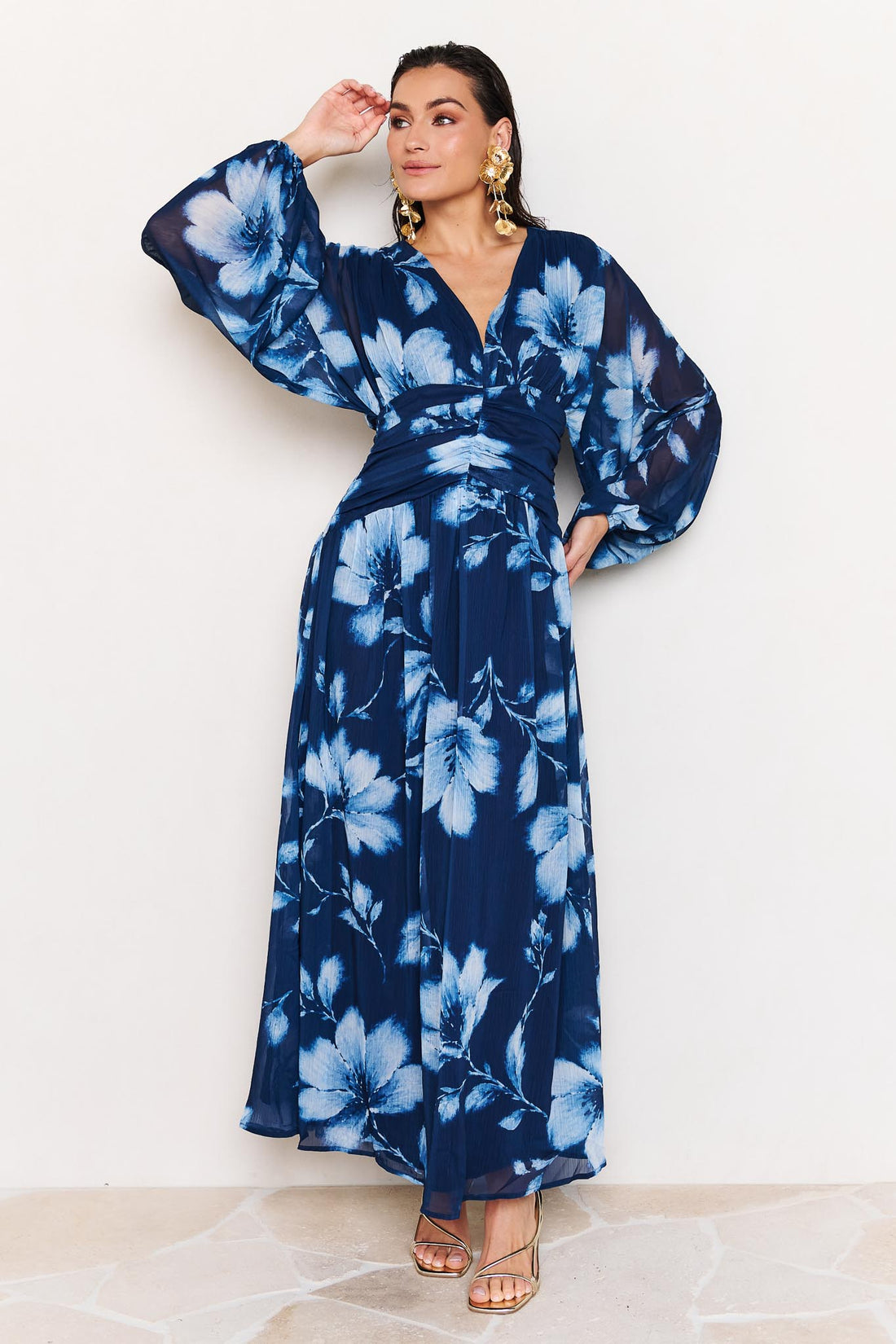 Woman wearing the minnie + MAXXIE Lola blue floral event dress on a white background
