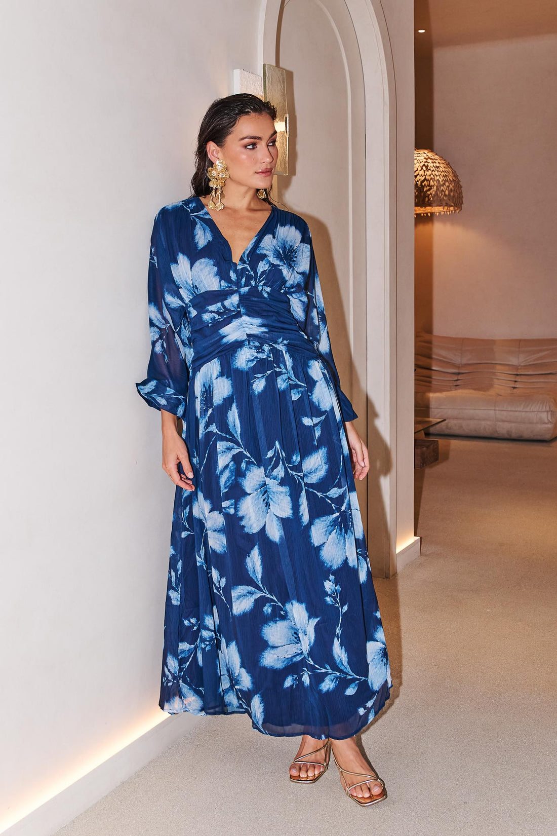 Woman wearing the minnie + MAXXIE Lola blue floral event dress in an indoor setting