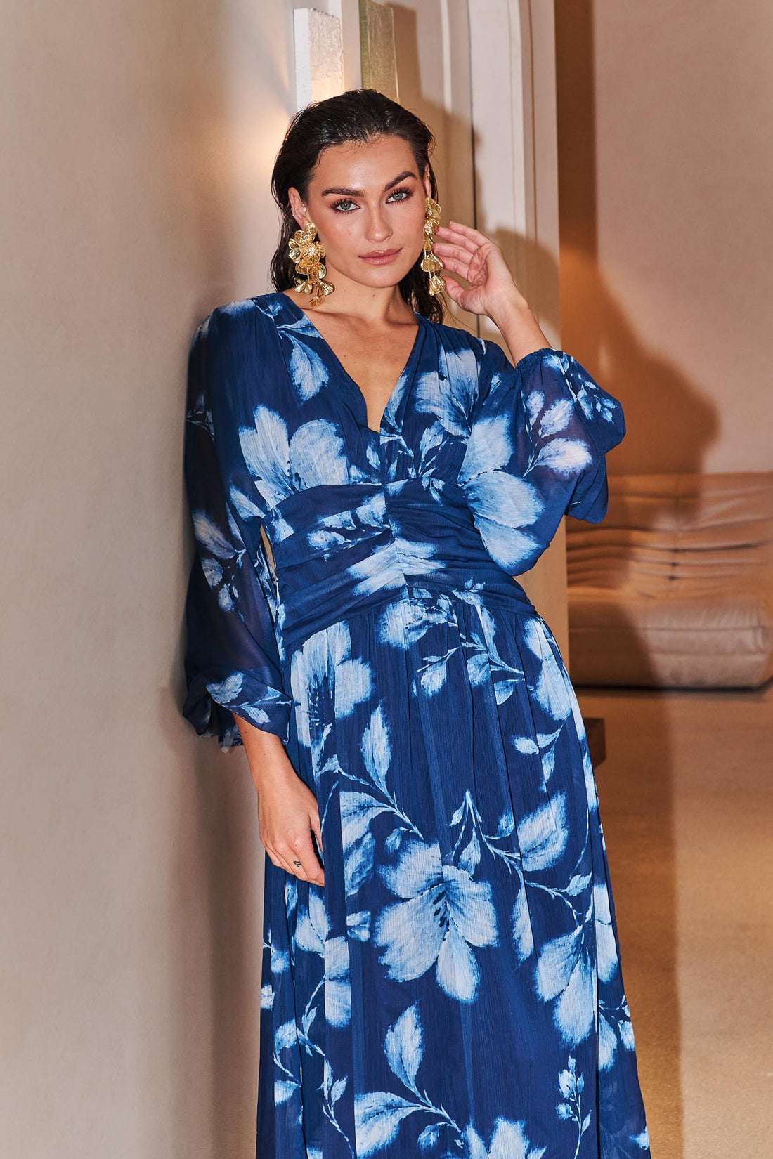 Woman wearing the minnie + MAXXIE Lola blue floral event dress in an indoor setting