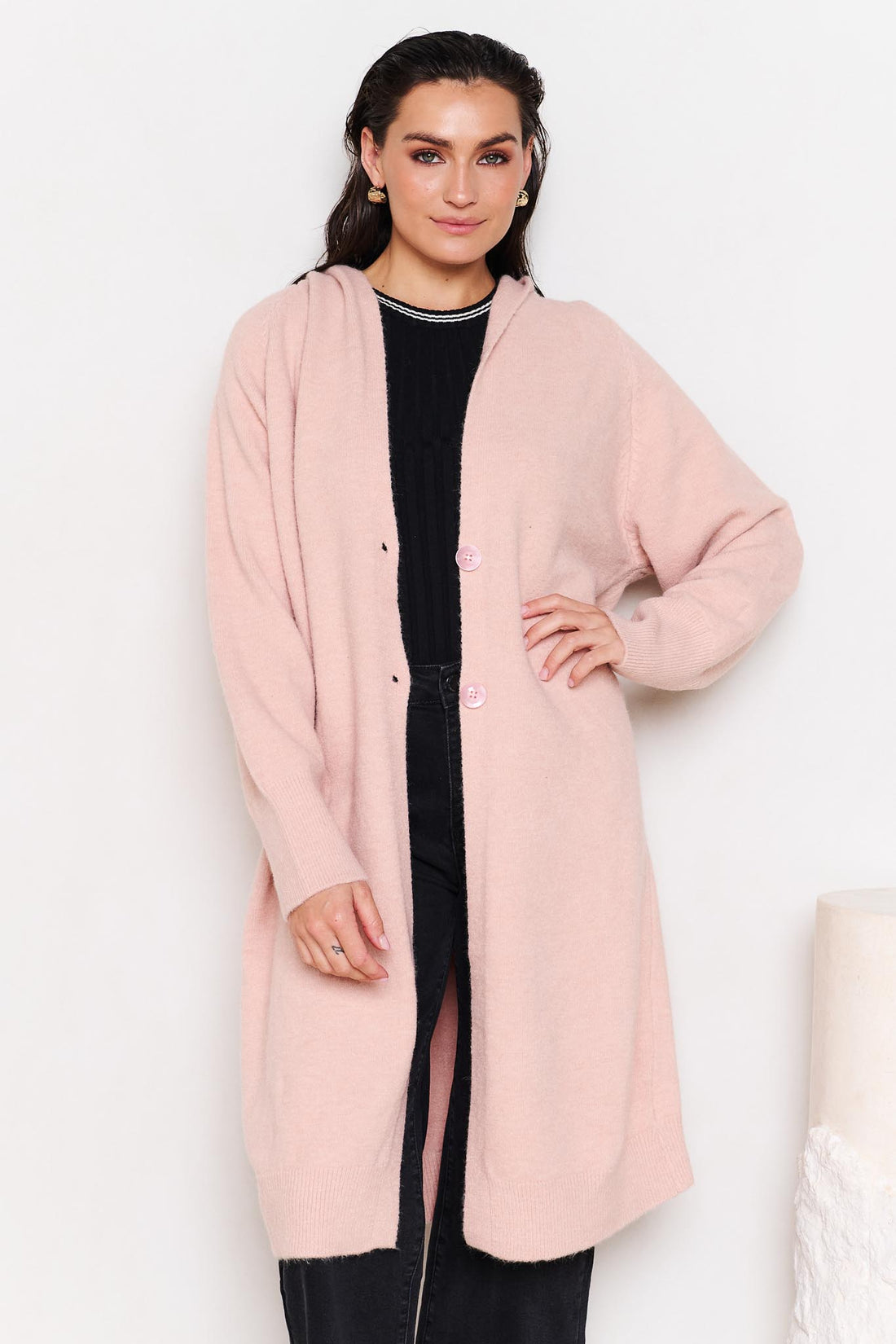 Woman wearing the minnie + MAXXIE Lennox longline hooded cardi with black jeans in a white room
