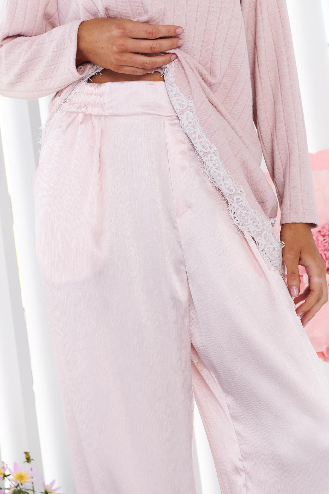 Detail of a woman wearing the minnie + MAXXIE pink Lila Lace Trim Satin Pant