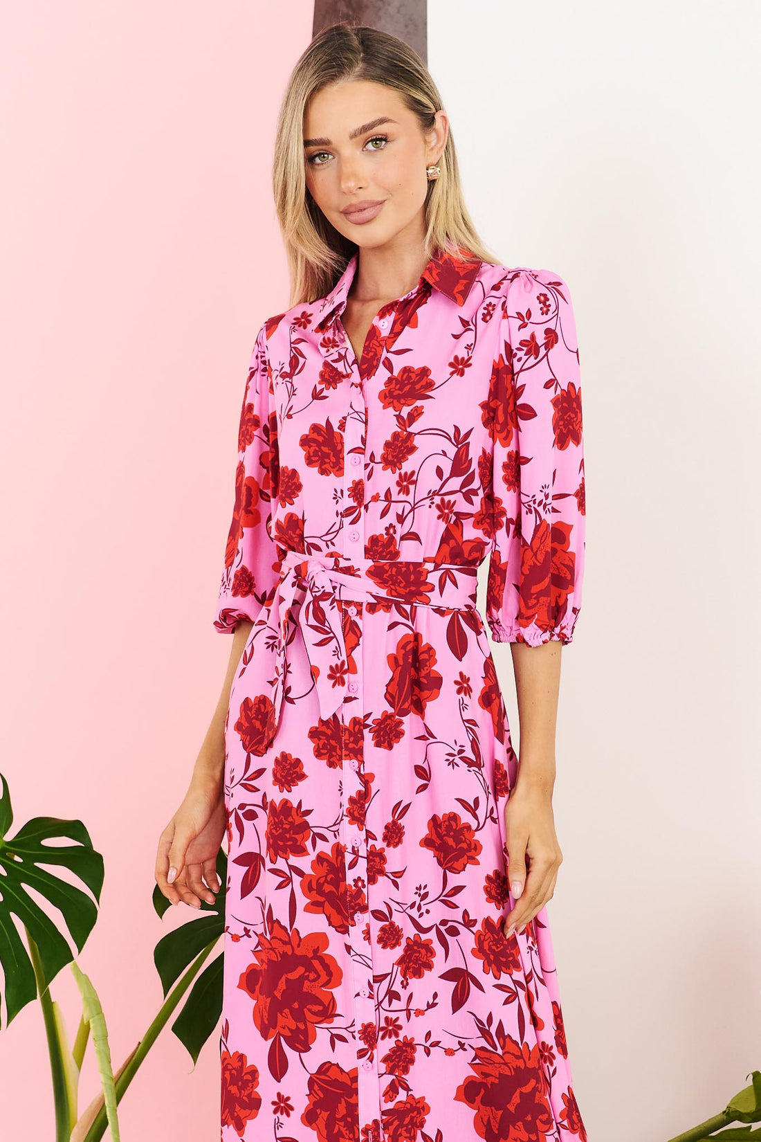 Close-up of Rosa floral shirt dress in hot pink with matching waist tie on a pink background