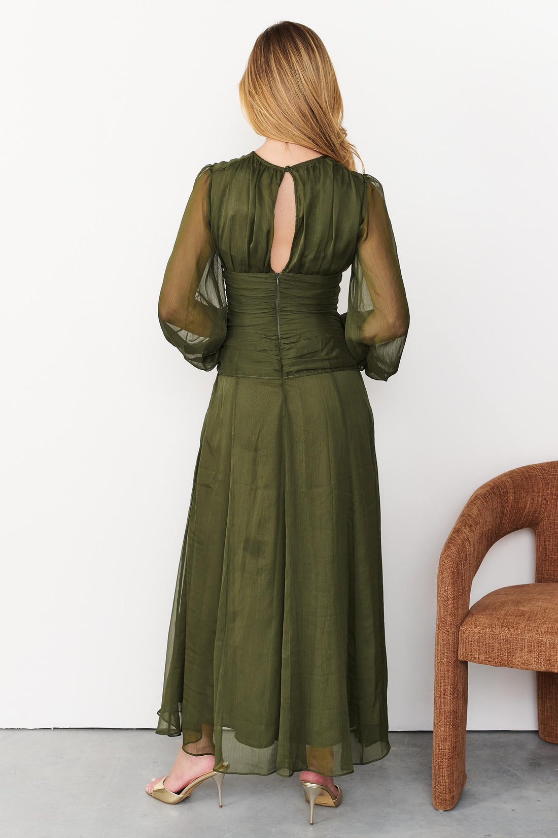 Back view of Sabine maxi event dress in olive green with a keyhole opening and long sheer sleeves.