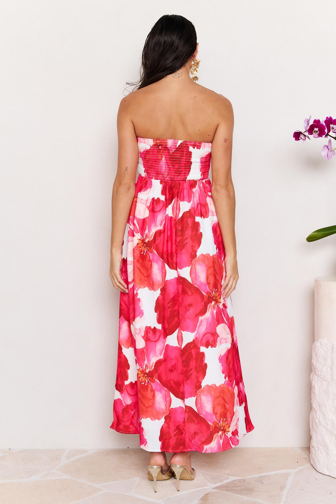 Back view of woman wearing the minnie + MAXXIE Sienna Strapless pink floral event dress