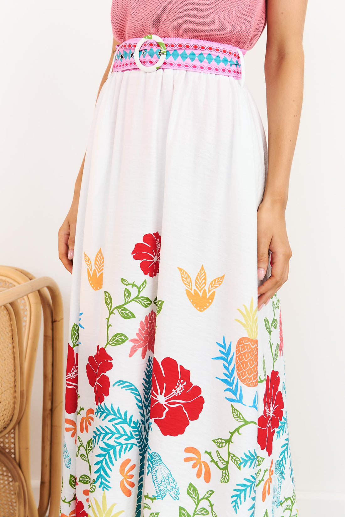 Close-up of Valencia floral maxi skirt with pineapple print and matching belt styled with pink Villa knit tank