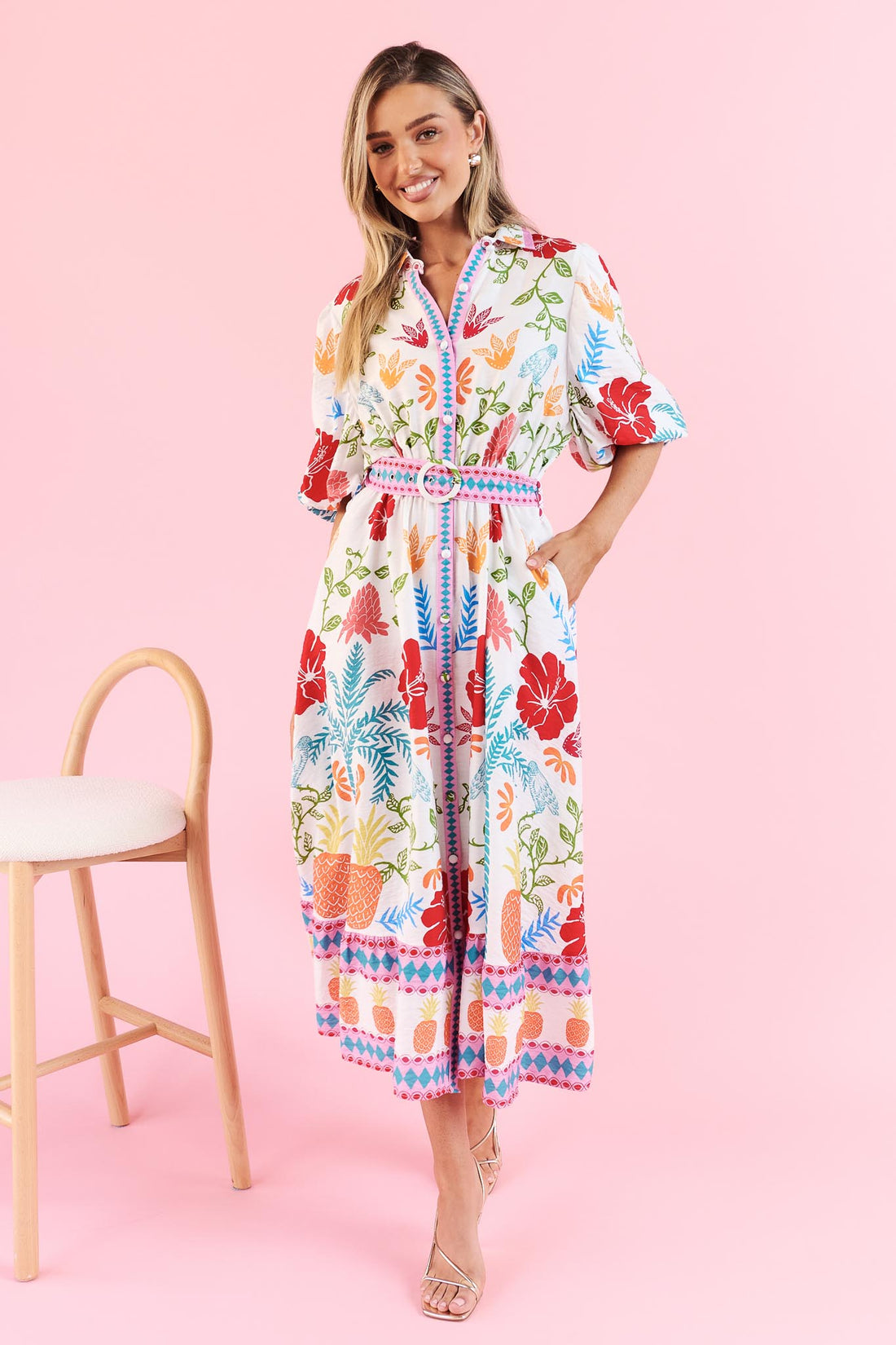 Valencia floral midi dress with pineapple print, short sleeves and matching belt on a pink background